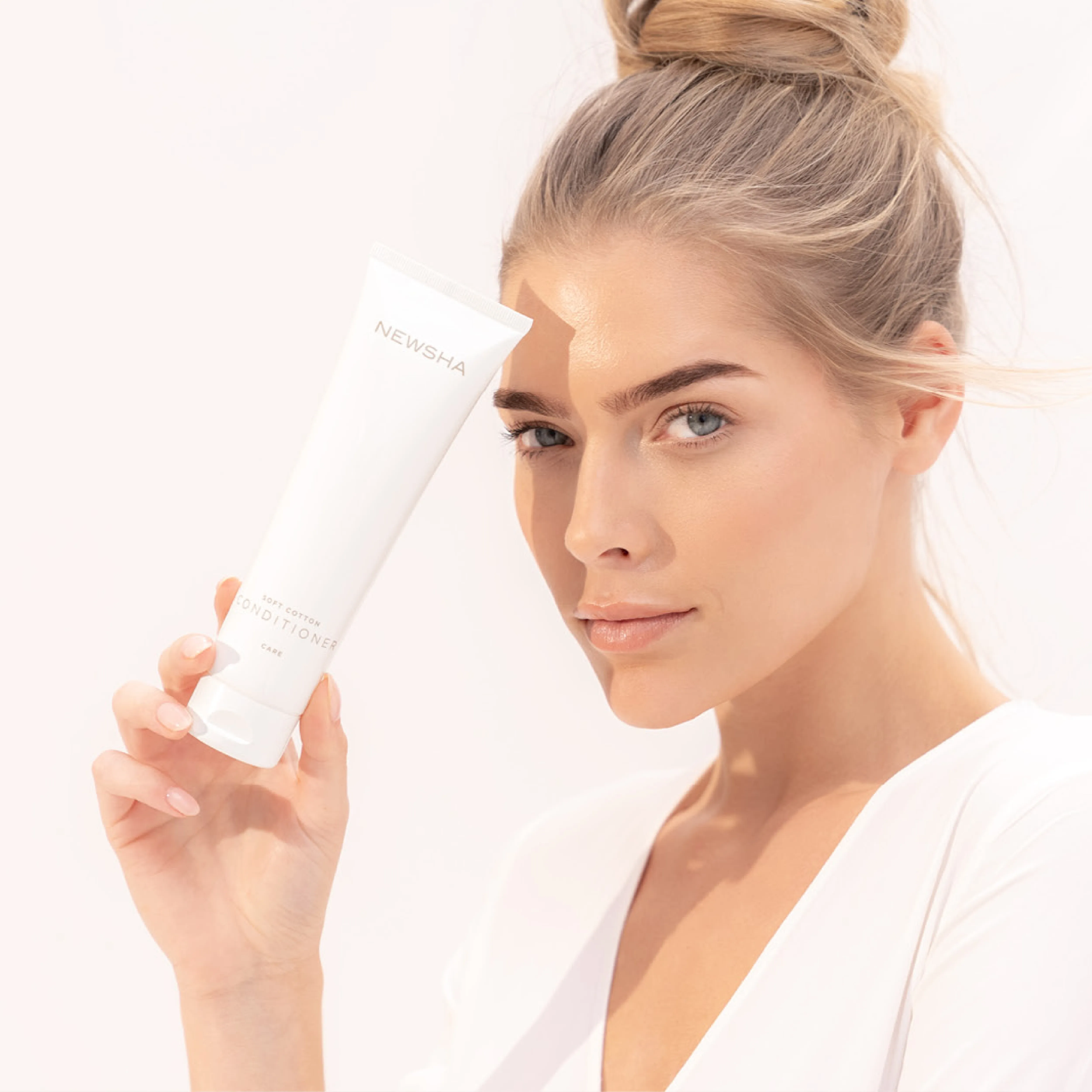 Blonde Frau beim Haarewaschen mit reichhaltigem Shampoo-Schaum und nassem Haar in Nahaufnahme